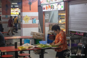 Dame qui découpe les légumes dans Chinatown