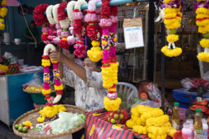 Dame qui pose un collier de fleurs dans son magasin