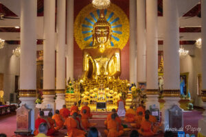 Moines devant un bouddha en or